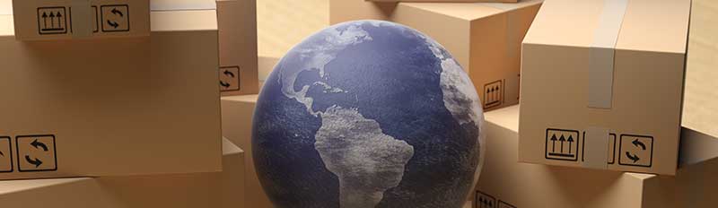 Weltkugel zwischen Umzugskartons als Symbol für internationale Umzüge
